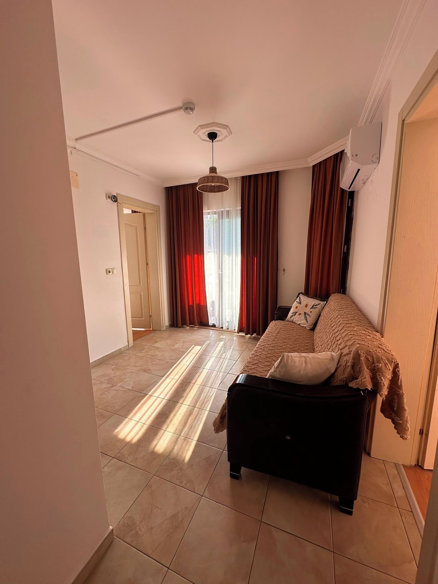 Ein Zimmer mit einem Bett, einem Deckenventilator und Blick ins Freie.