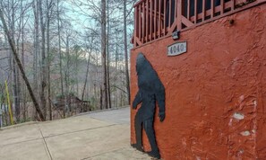 A building with a red exterior and a black figure painted on the wall. - Wears Valley Cabin | Hot Tub | Spacious Decks | Sleeps 8 (Sevierville)
