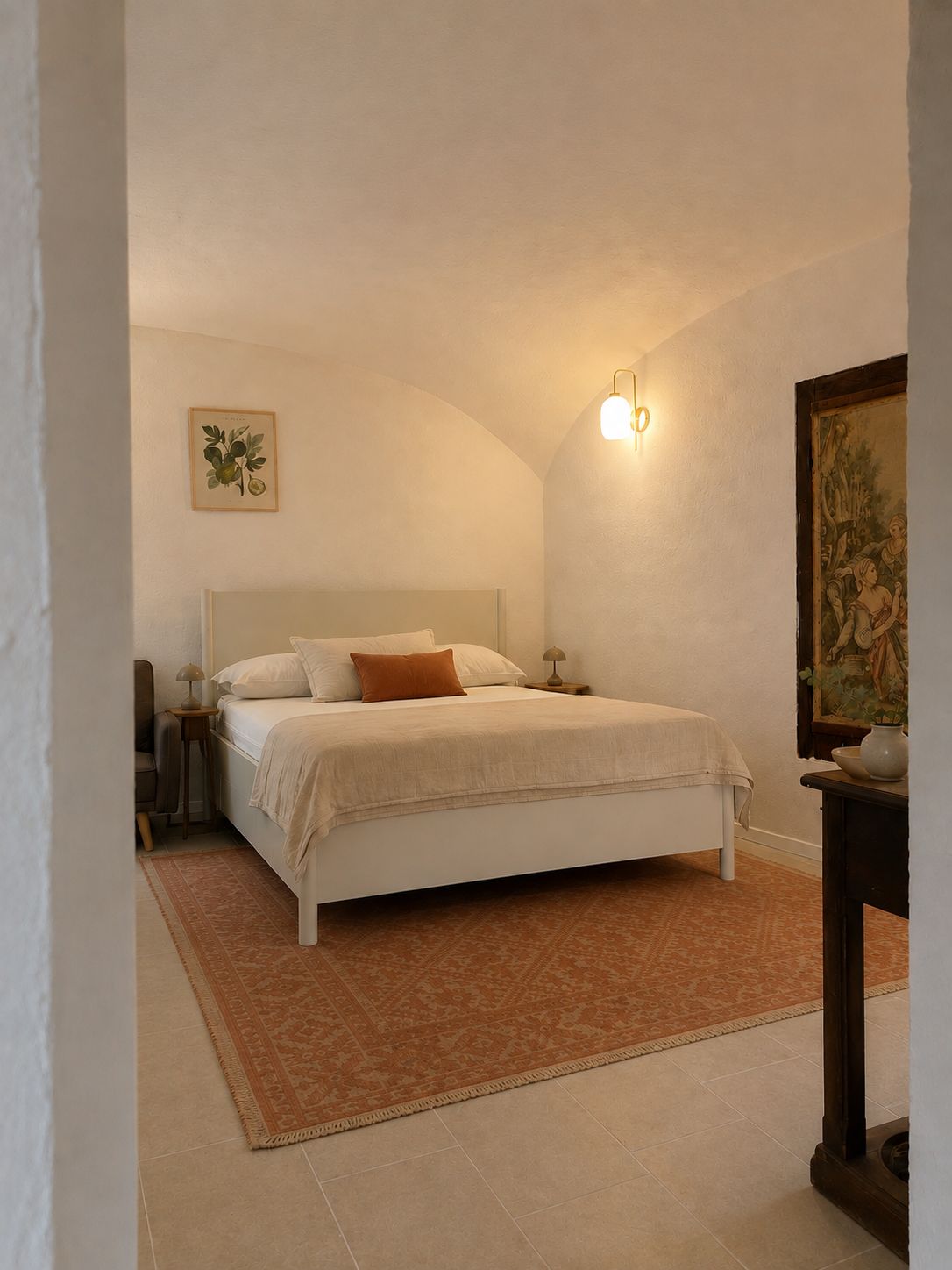 Een slaapkamer met een bed, een nachtkastje, een lamp, een vloerkleed en een schilderij aan de muur.