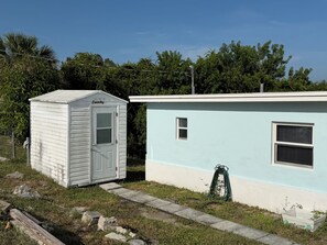 En lille, etetages bygning med vaskeri og et separat rum med vindue og ventilationsrist.