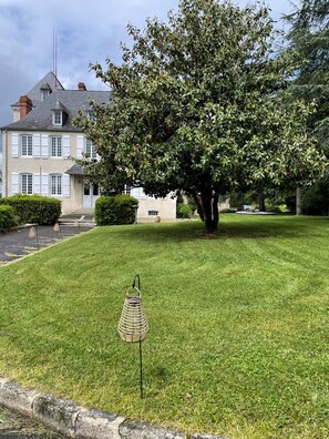 Une pelouse bien entretenue, avec un lampadaire en métal décoratif en premier plan.
