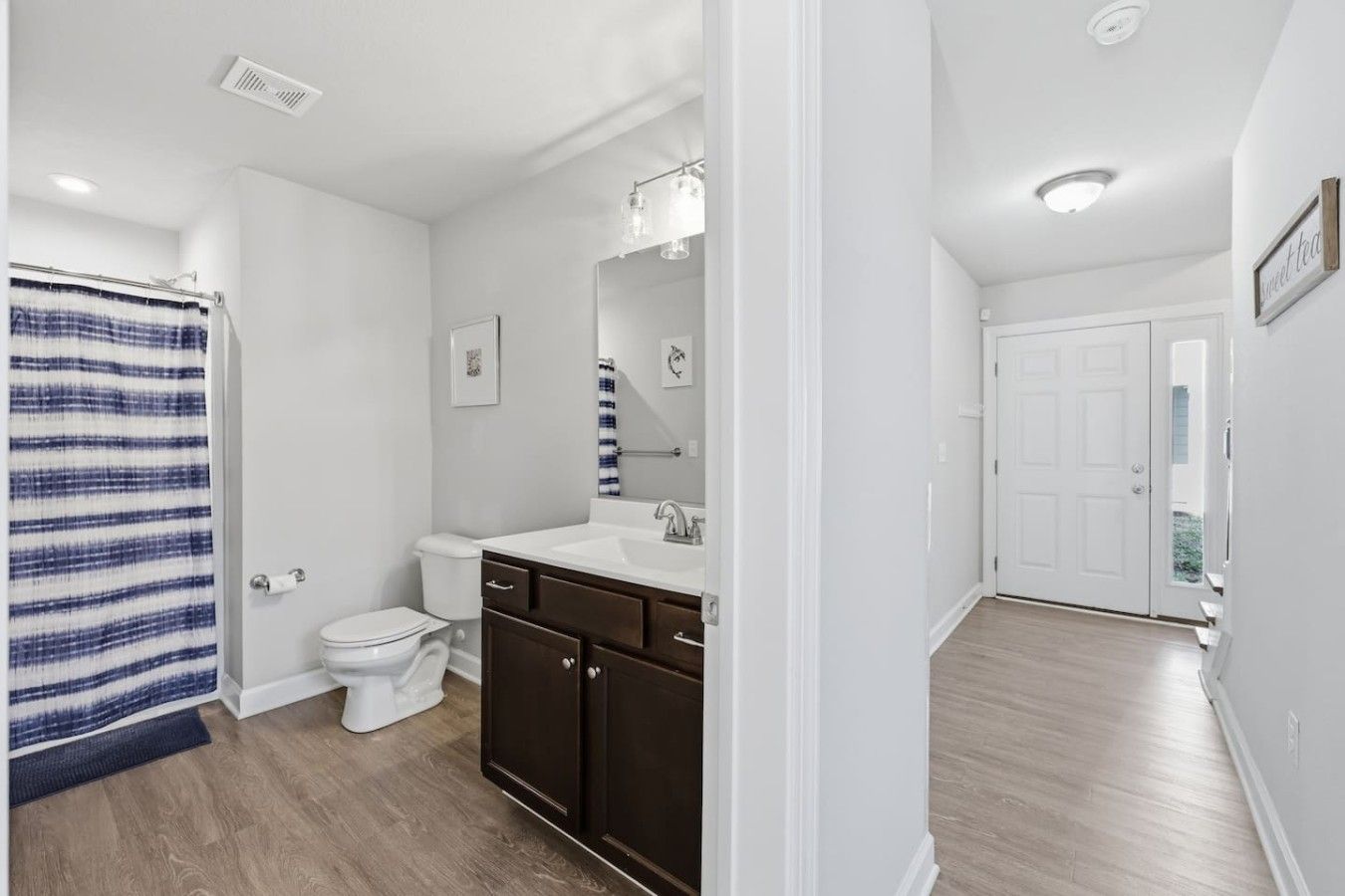 A bathroom with a shower, toilet, and vanity.