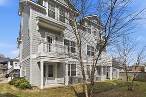 A multi-story residential building with a balcony, a front porch, and a small front yard. - VIBE 3BR | 2 Blks to Beach & 1 blck Atlantic Park (Virginia Beach)