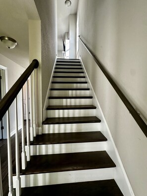 A staircase with wooden steps and white walls, leading to an upper floor. - Coastal 3BR | 2 Blks to Beach & Atlantic Park (Virginia Beach)