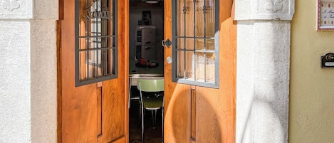An arched doorway with wooden doors and a tiled floor.