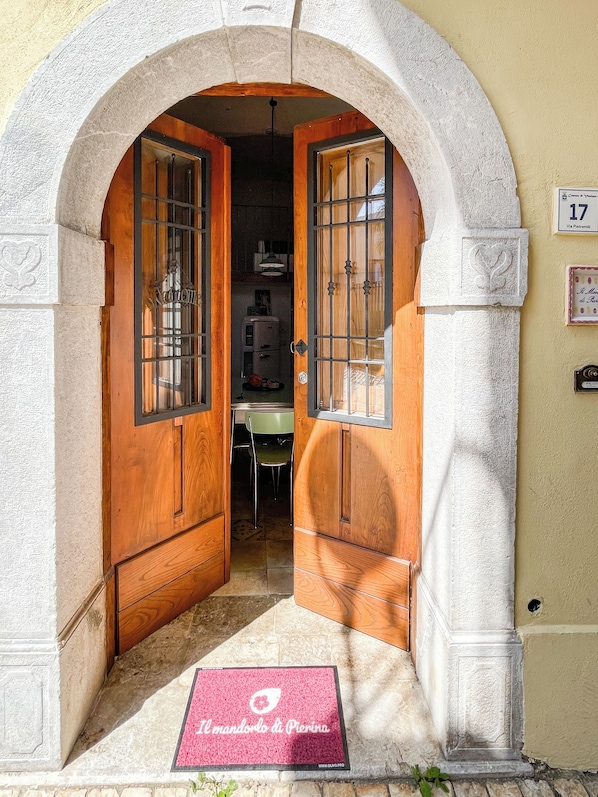 An arched doorway with wooden doors and a tiled floor.