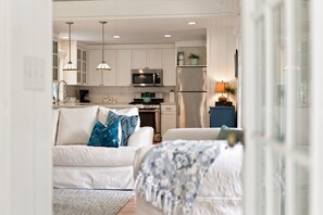 A modern kitchen with white cabinets, stainless steel appliances, and pendant lighting. - Lakeside Charmer Steps To Association Beach! (Lakeside)