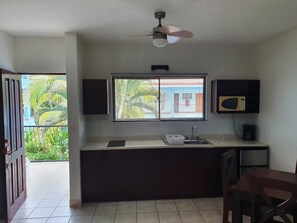 A compact kitchen with a window, a ceiling fan, and a microwave. - Marina Loft Unit 224,2 Floor (Sardinal)