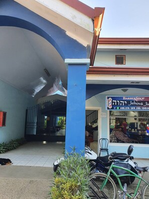 A building with a blue and white facade, a visible entrance, and a sign for a barber shop. - Marina Loft Unit 224,2 Floor (Sardinal)