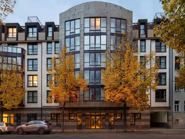 Un hotel de varios pisos con fachada curva, amplias ventanas y una entrada central.