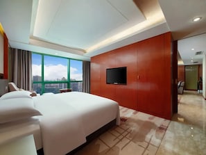 A hotel room with a large bed, a flat-screen TV mounted on the wall, and a view of the city through large windows. - Chongqing Empark Grand Hotel (Chongqing)