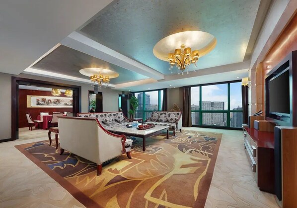A spacious living area with a high ceiling, a large window offering a city view, a sofa, a coffee table, and a television. - Chongqing Empark Grand Hotel (Chongqing)
