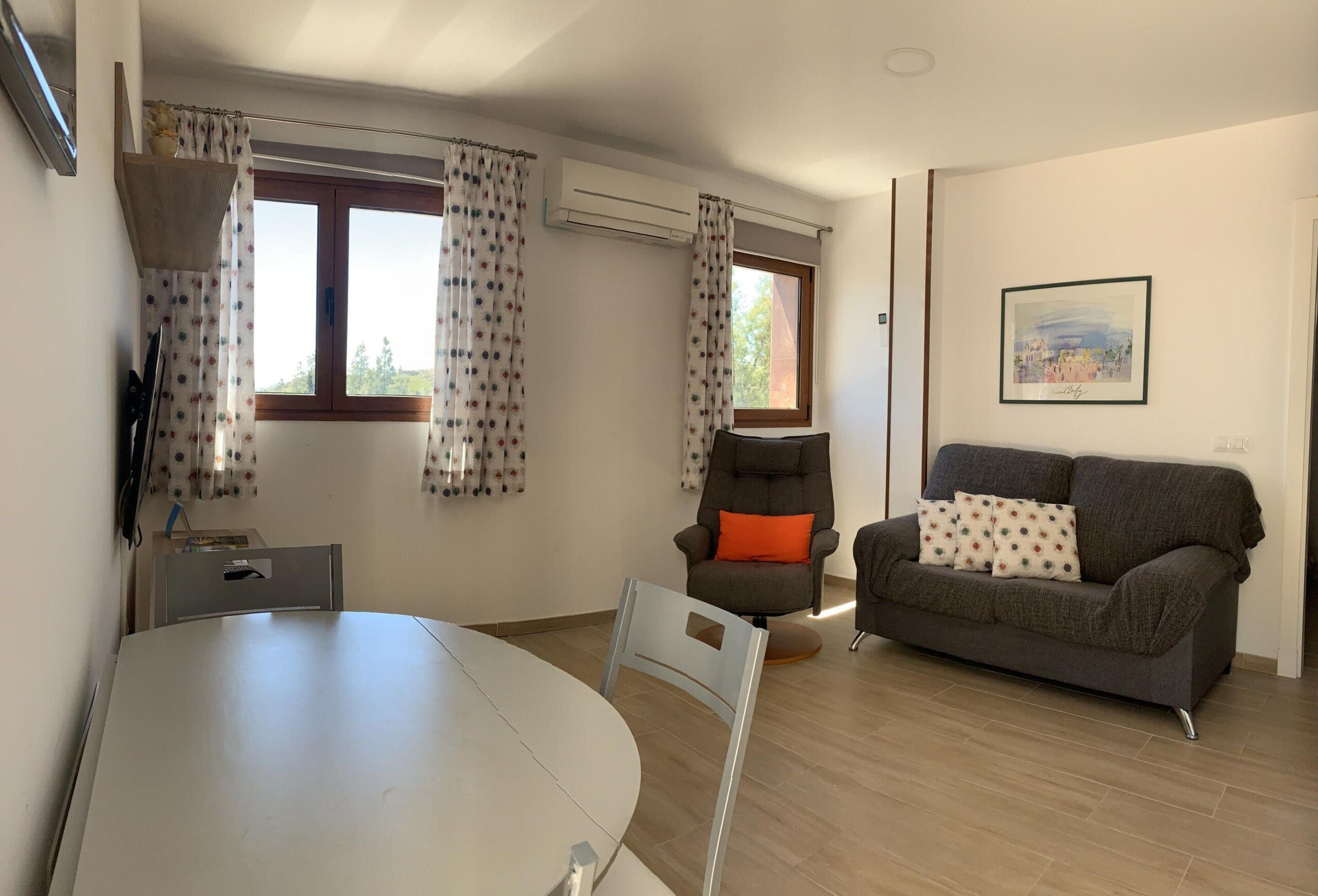 A living room with a dining table, two sofas, and a chair.