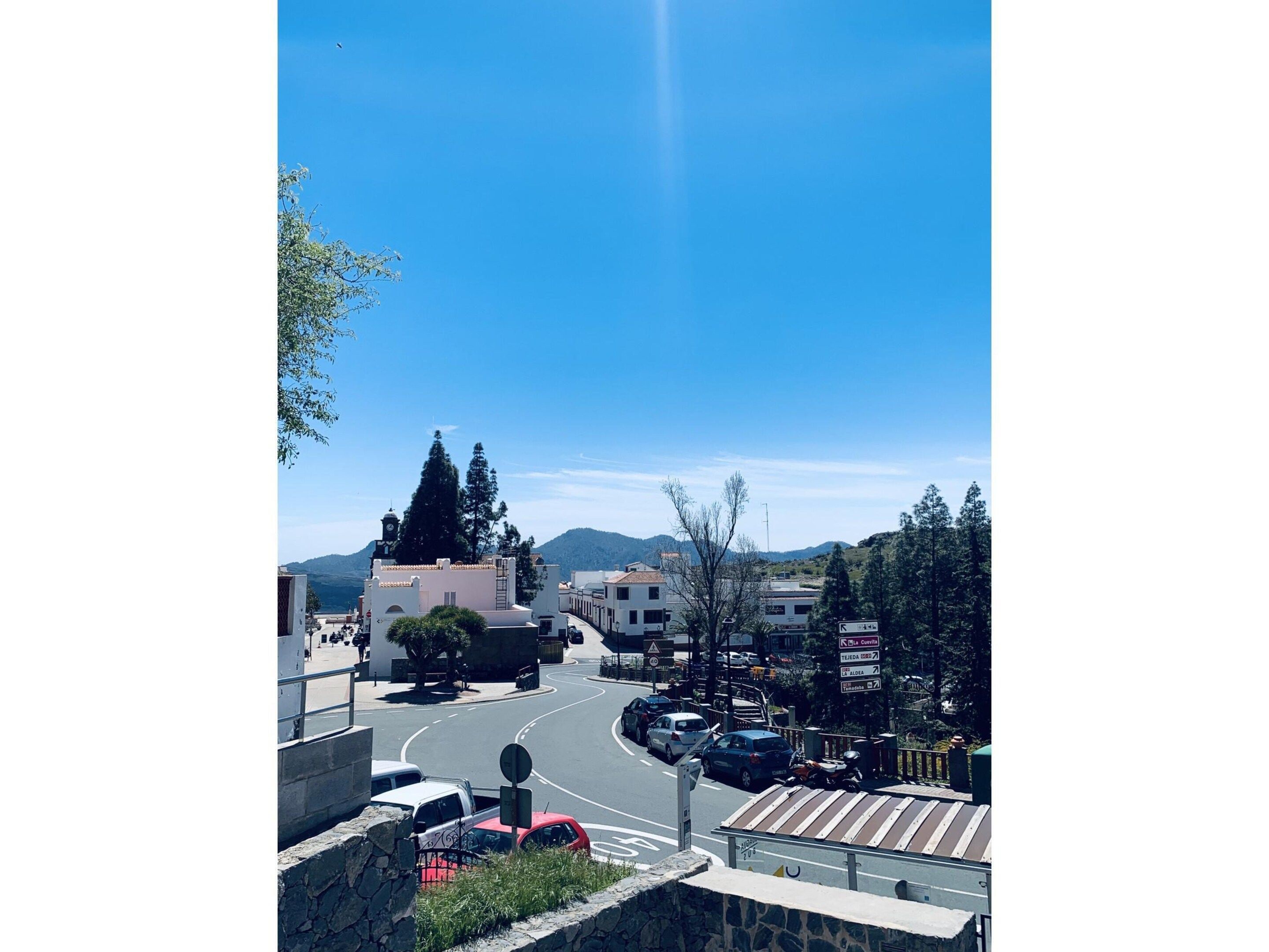 Eine Küstenstadt mit blauem Himmel, einer gewundenen Straße und Gebäuden im mediterranen Stil.