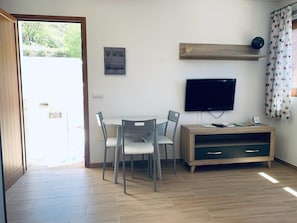 A room with a dining table, chairs, a television, and a cabinet. - Apartment La Solanita for Relaxing Retreat (Artenara)