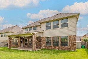 A two-story house with a brick facade, large windows, and a covered porch. - Spacious 4BR Richmond Home w/ Game & Media Room (Richmond)