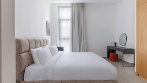 A modern hotel room with a large bed, a desk, and a wardrobe. - Sahab - Sunset 1BR at Al mamsha Sharjah (Sharjah)