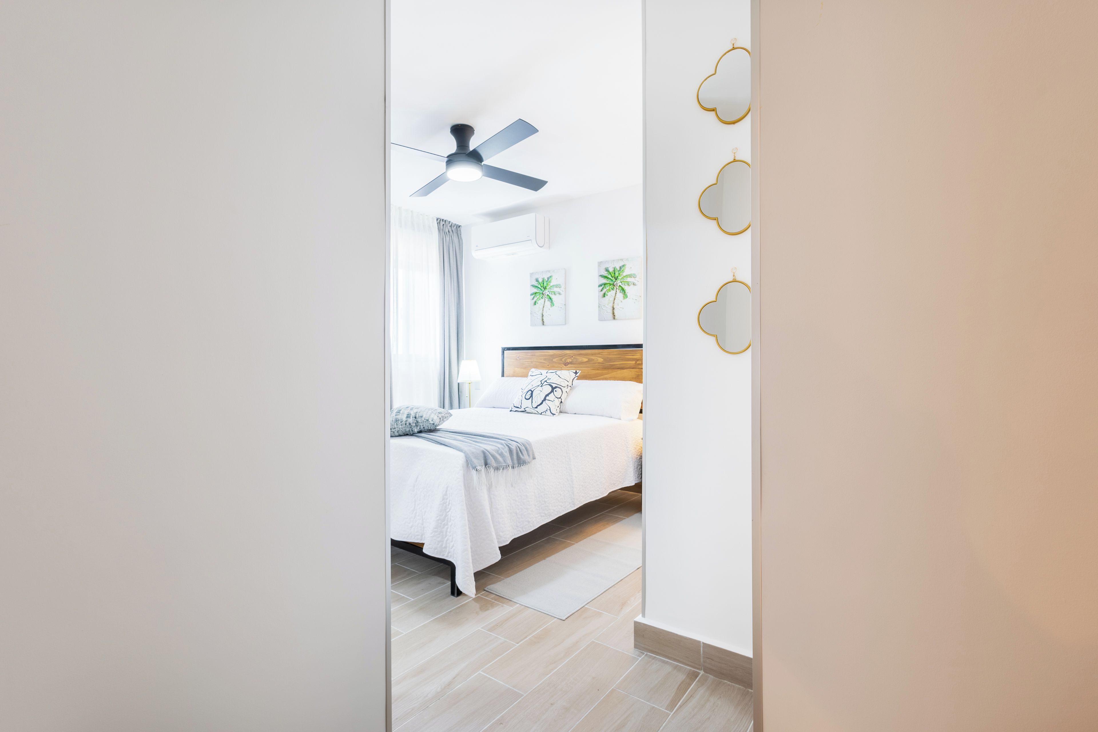 Ein modernes Schlafzimmer mit einem Bett, einem Deckenventilator und Wandbildern.