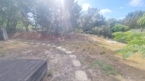 A garden with a stone pathway leading to a wooden deck. - Large family apart with garden, close to the beach (Arcachon)