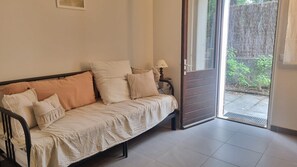 A room with a sofa, a lamp, and a sliding glass door leading to an outdoor area. - Large family apart with garden, close to the beach (Arcachon)