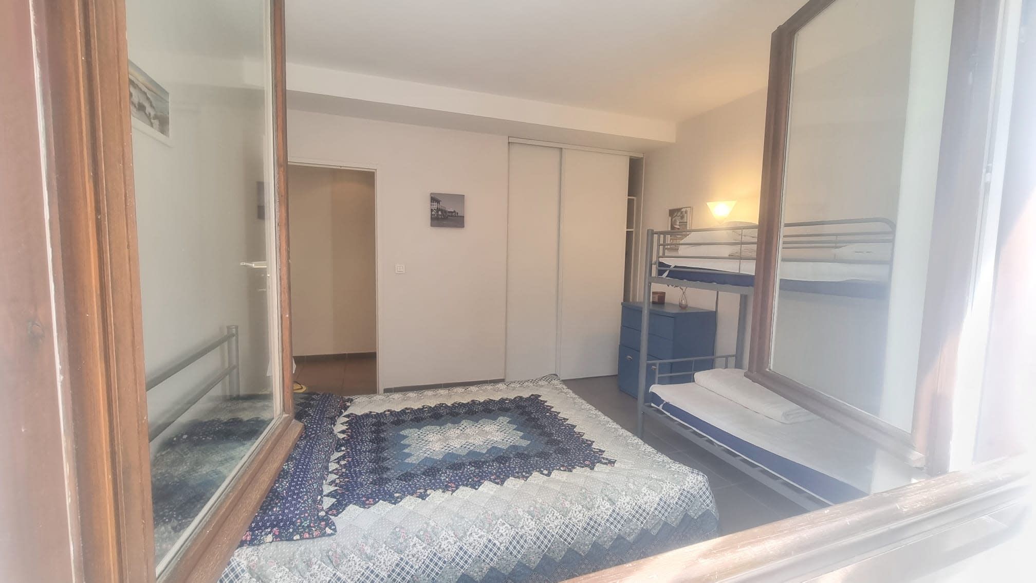 Una habitación con una litera, un escritorio pequeño y una alfombra estampada.