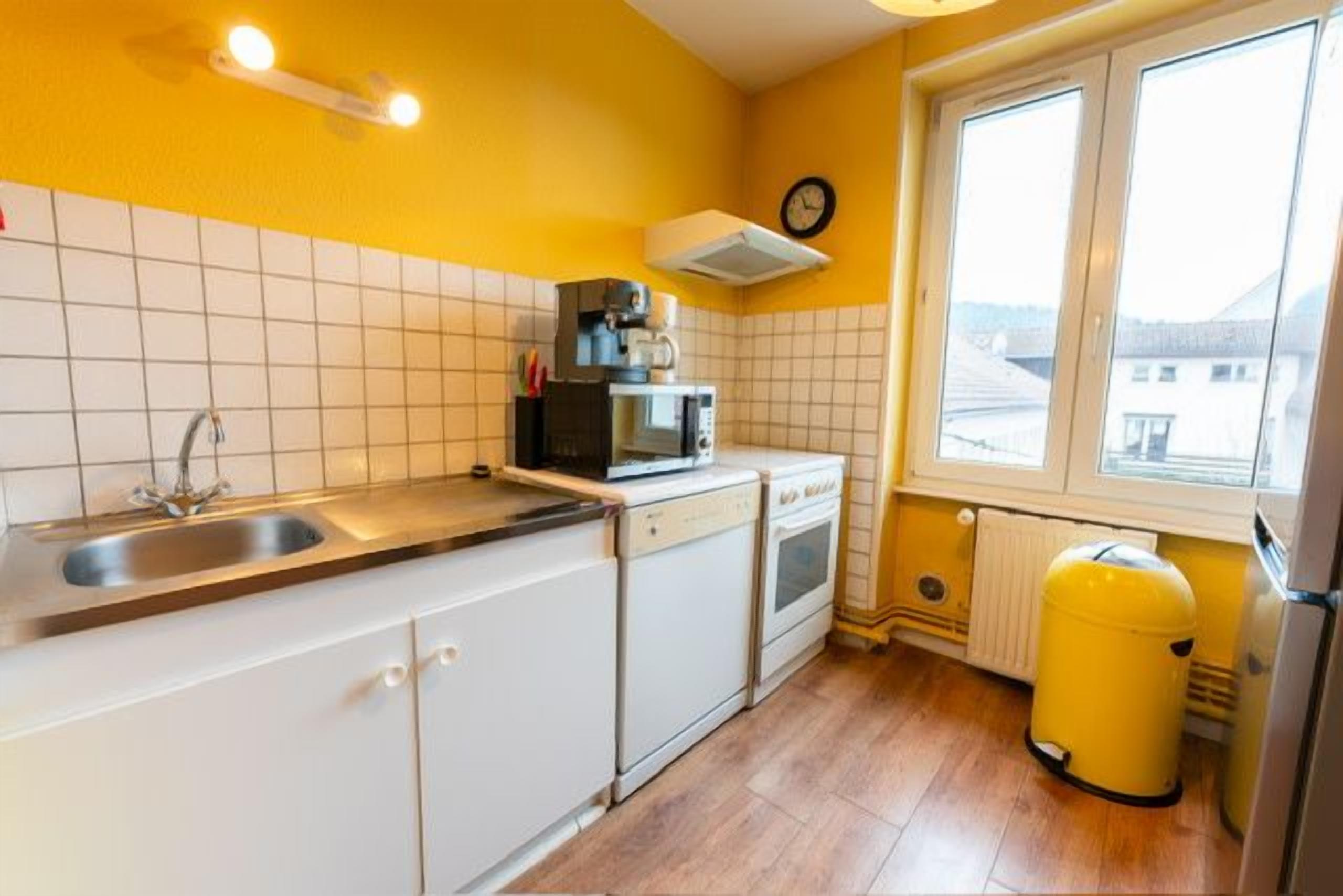 A compact kitchen with a sink, stove, and microwave.