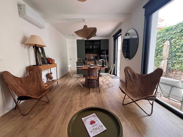Un interior moderno con comedor, cocina y ventanas amplias.