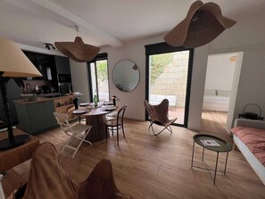 Un interior moderno con comedor, cocina y un ventanal que proporciona luz natural.
