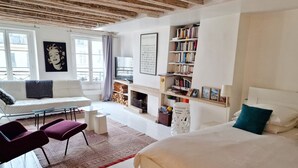 Ein modernes Schlafzimmer mit einem großen Bett, einem weißen Sofa, einem Kamin und einem Bücherregal.