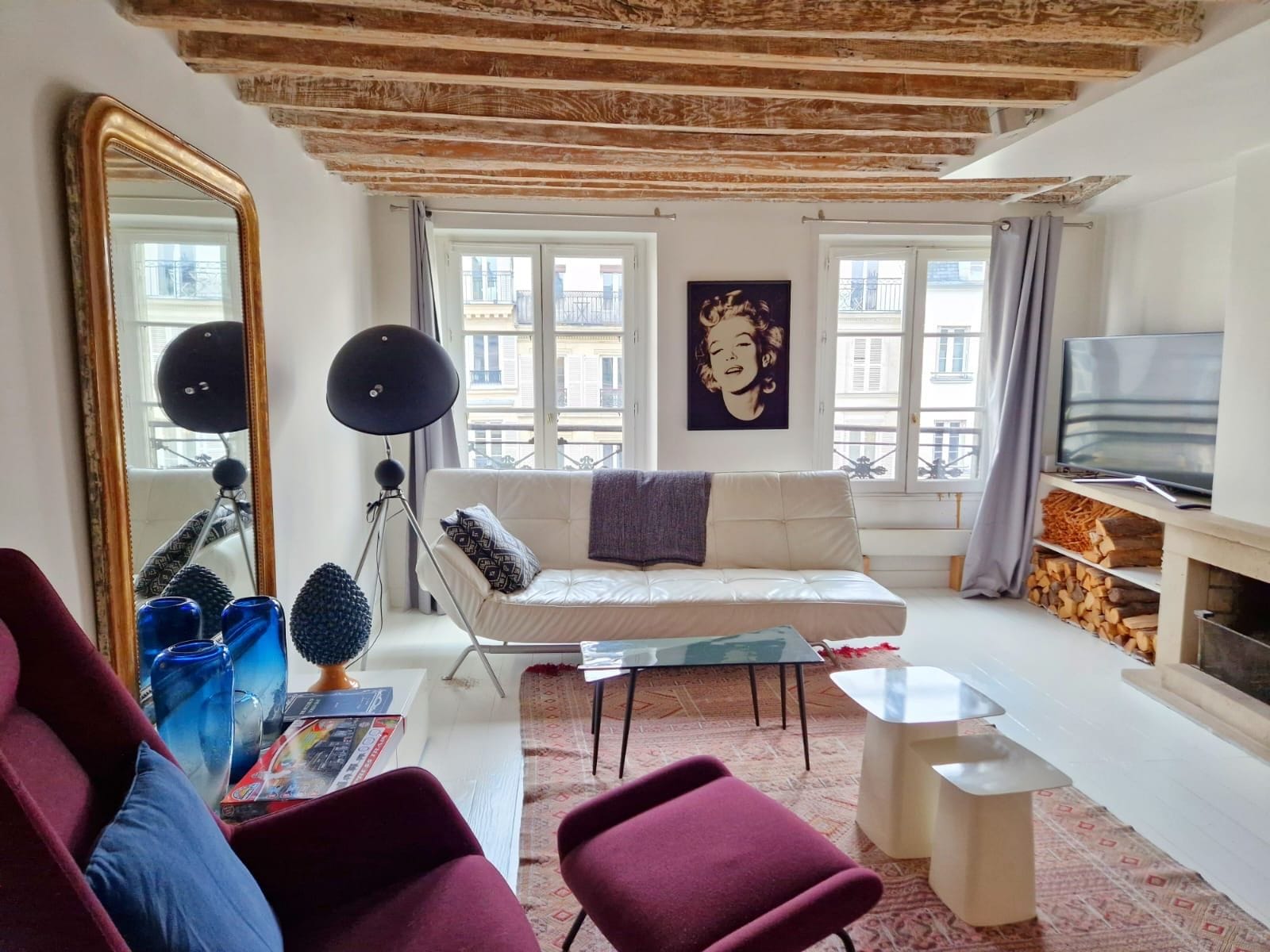 Uma sala de estar com sofá, mesa de centro, televisão e lareira.