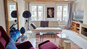 Ein Wohnzimmer mit einer Couch, einem Couchtisch, einem Fernseher und einem Kamin.