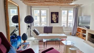Una sala de estar con sofá, mesa de centro, televisor y chimenea.