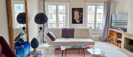 Ein Wohnzimmer mit einer Couch, einem Couchtisch, einem Fernseher und einem Kamin.