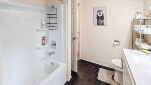 A bathroom with a bathtub, toilet, and sink. - Warren Wilderness - A Unique Architectural Gem Near the Allegheny River and Kinzua Dam (Warren)