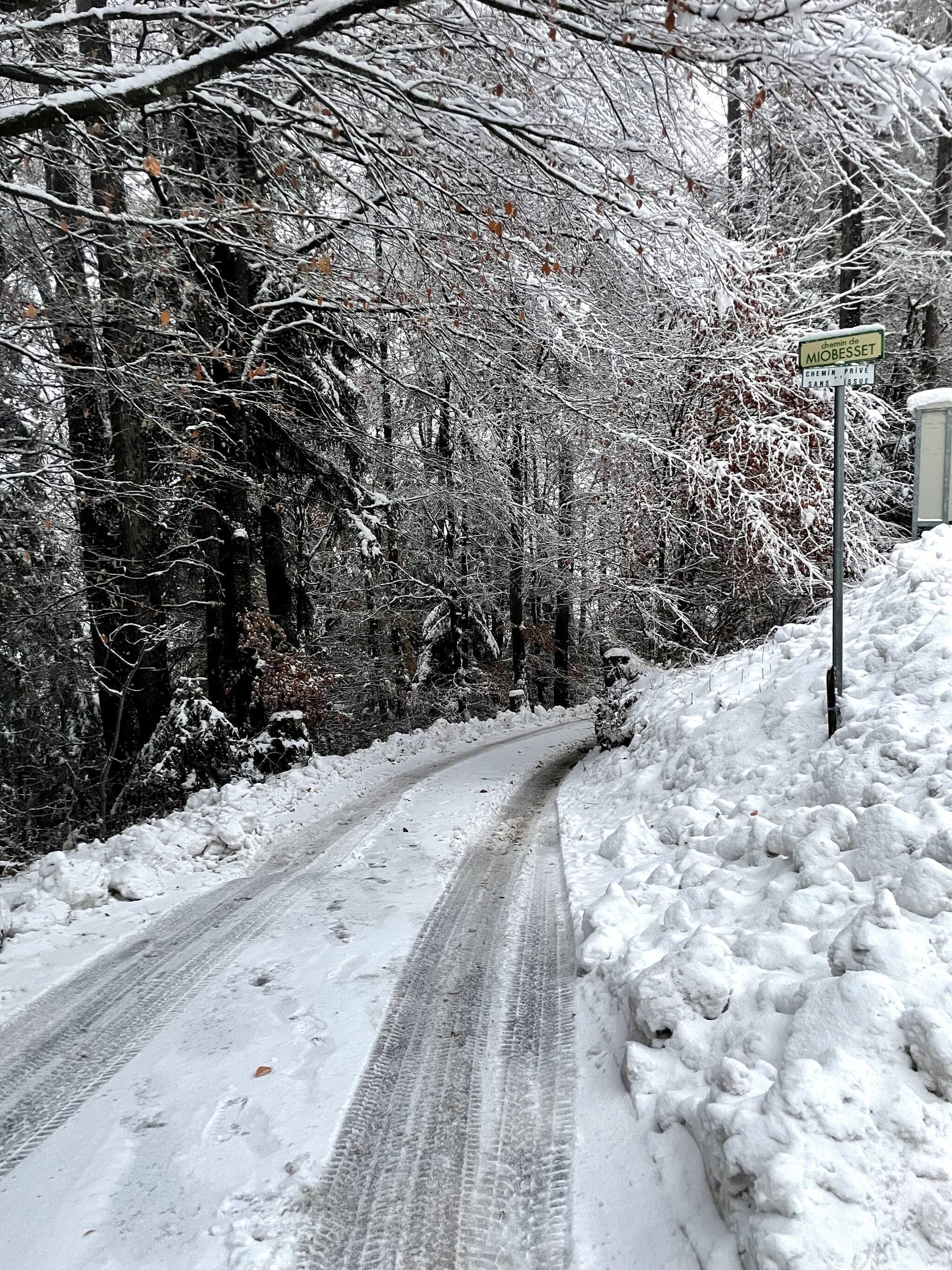 Een besneeuwde weg met een bord dat aangeeft dat het een privéweg is.