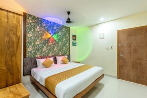 Quarto com cama, cabeceira de madeira, ventilador de teto e uma porta.