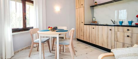 A compact living space with a dining area, kitchenette, and a sofa.