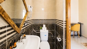 Ein Badezimmer mit großem Spiegel, einer Badewanne, einer Toilette und einer Duschkabine.