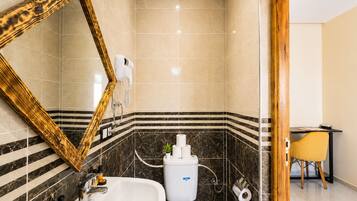 Ein Badezimmer mit großem Spiegel, einer Badewanne, einer Toilette und einer Duschkabine.