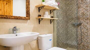 Ein Badezimmer mit Waschbecken, Toilette und Duschbereich.
