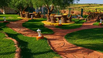 Ein angelegter Garten mit einem gewundenen Weg, Baumstümpfen und Gartenmöbeln.