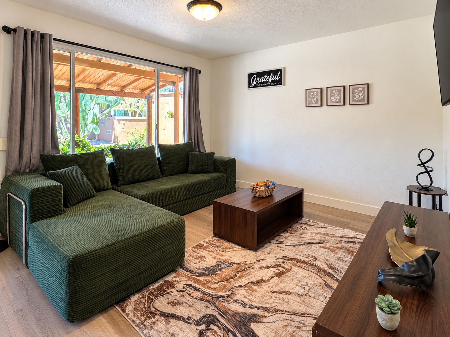 A living room with a sectional sofa, a coffee table, and a rug.