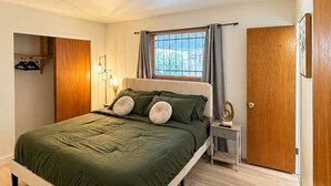 A bedroom with a bed, a nightstand, a wardrobe, and a window with curtains. - Desert Oasis w/ Private Pool Near ASU (Tempe)