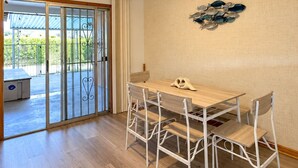 A dining area with a table and chairs, a ceiling light, and a view through a glass door to an outdoor space. - Desert Oasis w/ Private Pool Near ASU (Tempe)