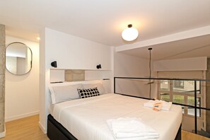 Una camera da letto moderna con un letto, comodini, uno specchio e una finestra.