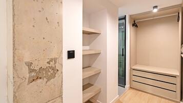 Una habitación con pared blanca, suelo de madera y armario empotrado con puertas correderas.