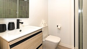 A modern bathroom with a white sink, black faucet, and a toilet. - GuestReady - Apartment with Mezzanine in Benicalap (Valencia)