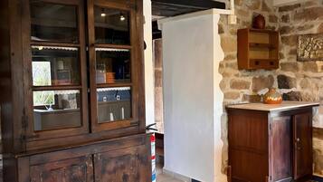 Una cocina rústica con piso de cuadros, armarios de madera y pared de piedra.
