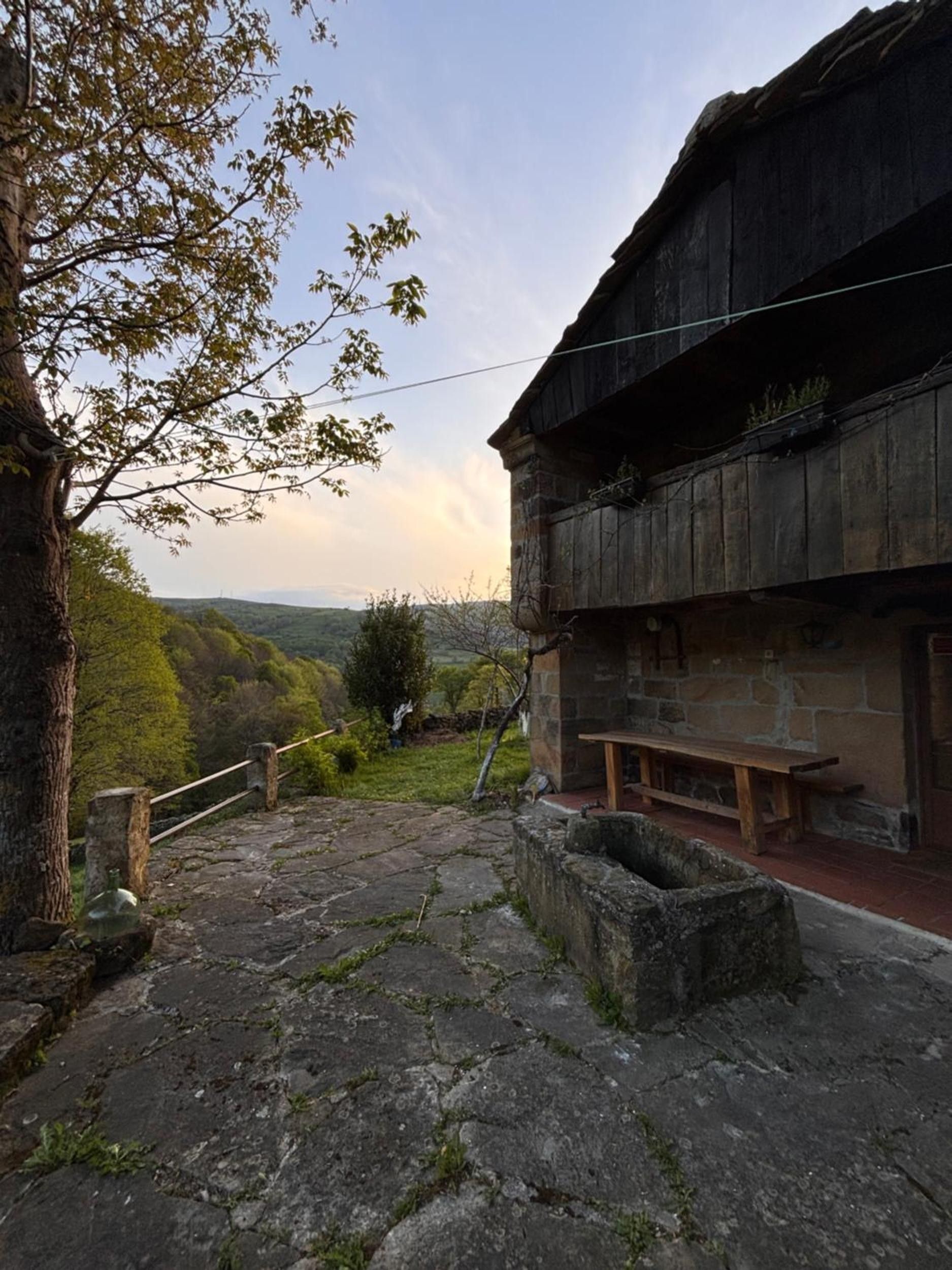 Un bâtiment rustique en pierre, avec un banc en bois et un mur de pierre.