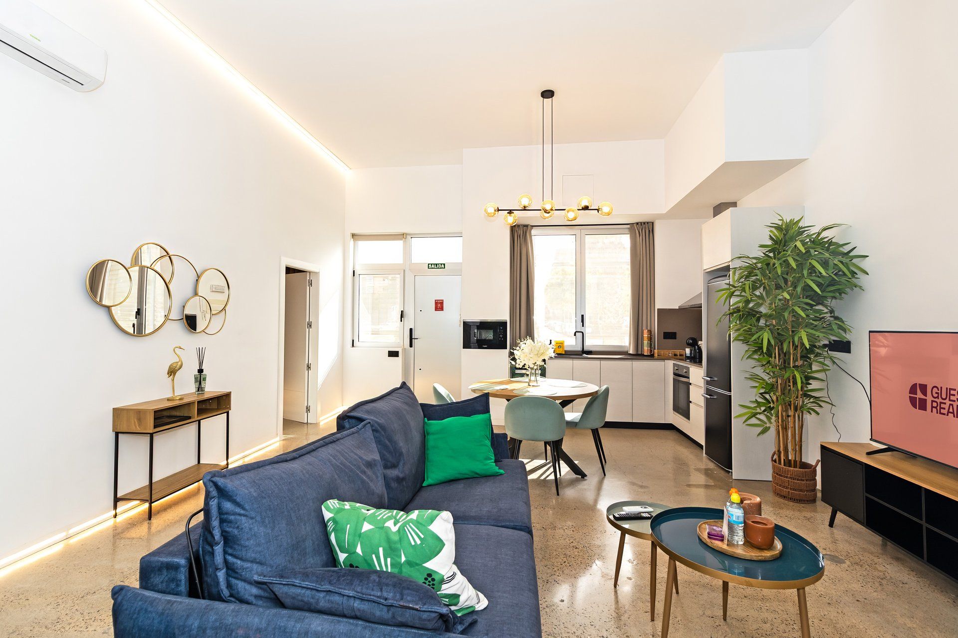 Una sala de estar moderna con un sofá, un comedor y una cocina.
